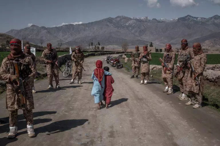 पूर्वी अफ़ग़ानिस्तान के लगमन सूबे में स्थित अलिंगर ज़िले में तैनात एक उत्कृष सैन्यबल-तालिबान रेड यूनिट के बीच से गुज़रते हुए अफ़ग़ानी बच्चे (फ़ाइल फ़ोटो)
