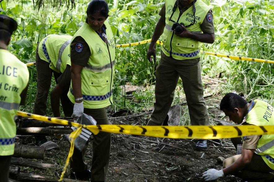 Police officers work at the explosion site in Pugoda on the east outskirts of Sri Lankan capital Colombo